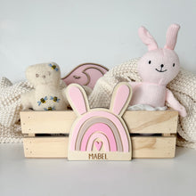 Load image into Gallery viewer, Wooden crate with stuffed animals and a pink rabbit-shaped toy on a light background

