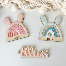 Load image into Gallery viewer, Three decorative name tags shaped like rainbows with bunny ears on a white surface.

